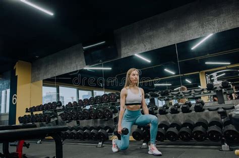 Low Angle View Of Sporty Young Couple Training With Dumbbells In Gym