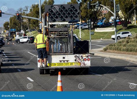 Worker Behind Utility Truck Placing Bright Orange Traffic Cones On