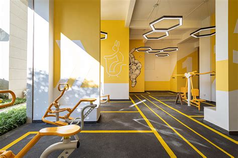 整个运动健身架空层与社区室外运动场地相邻，架空层设计延续室外景观线性元素，将ip延伸为墙绘和导视系统搭配橙黄色，营造活力四射的空间氛围。