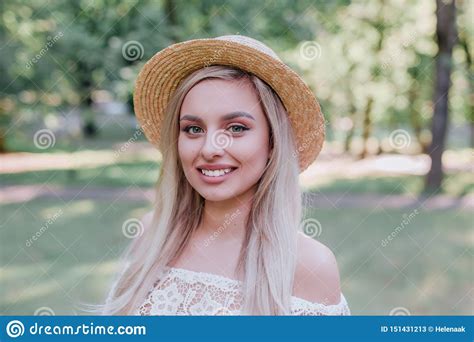 close up portrait of a beautiful blond hair girl in vintage straw hat standing outdoor stock