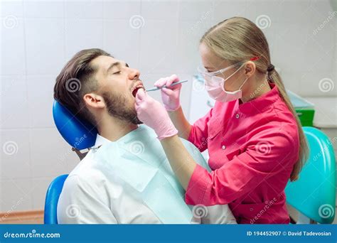 Professional Teeth Cleaning Dentist Cleans The Teeth Of A Male Patient
