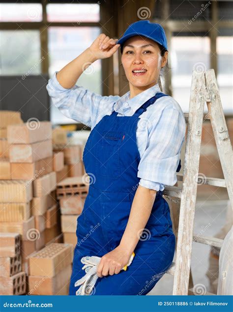 Portrait Of A Woman Builder Posing Near A Stepladder Stock Photo