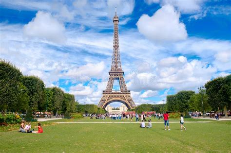 The Eiffel Tower And Tourists At The Champ De Mars On A Summer Day In