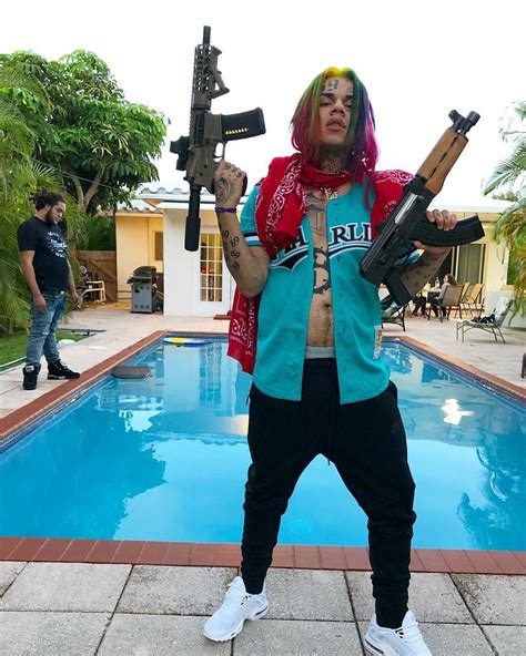 tekashi 6ix9ine risks revealing his location by posing with wads of cash on balcony as he lays