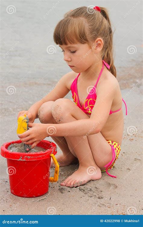 Muchacha Que Juega Con La Arena En La Orilla De Mar Foto De Archivo Imagen De Beb Castillo