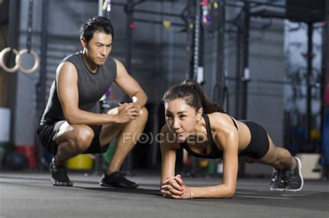 Chinese Woman Doing Push Ups With Trainer In Gym — Exercise Sport