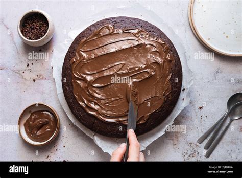 Icing Being Spread On To A Chocolate Cake Stock Photo Alamy