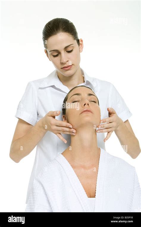 Massage Therapist Giving Neck Massage To Woman With Her Head Back And