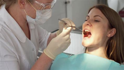 Dentist Treating Teeth To Woman Patient In Clinic Female Professional