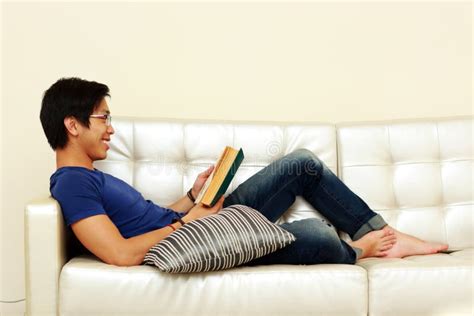 Man Reading A Book While Relaxing On Sofa Stock Image Image Of