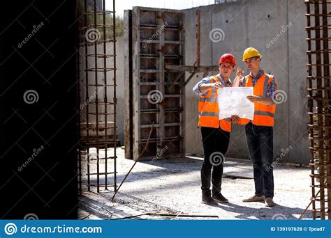 Structural Engineer And Construction Manager In Orange Work Vests And