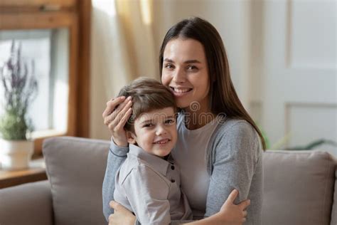 Retrato De Mamá Feliz Y Niño Pequeño Abrazado En El Sofá Foto De