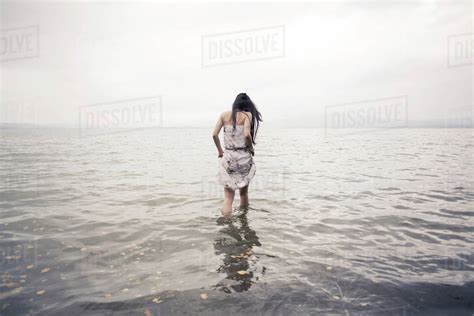 Caucasian Woman Wading In Water On Beach Stock Photo Dissolve