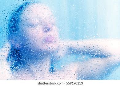 Beautiful Woman Shower Behind Glass Drops Stock Photo
