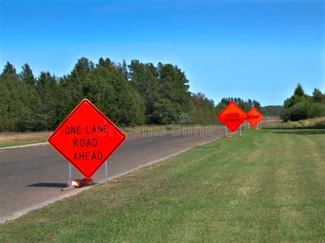 Orange Warning Road Signs On Highway At Construction Site Stock Photo