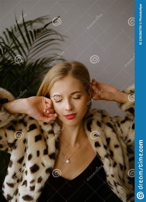Portrait Of A Young Caucasian Woman With Long Blond Hair Wearing A Leopard Fur Coat The Blonde
