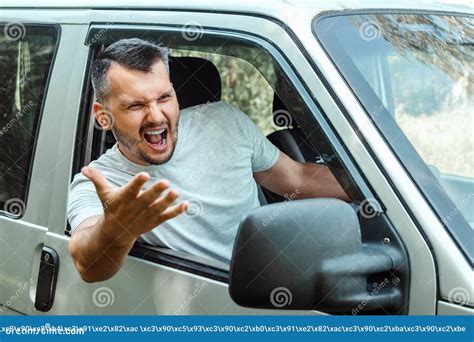 Aggressive Man The Driver Of The Car Is Outraged At The Wheel During