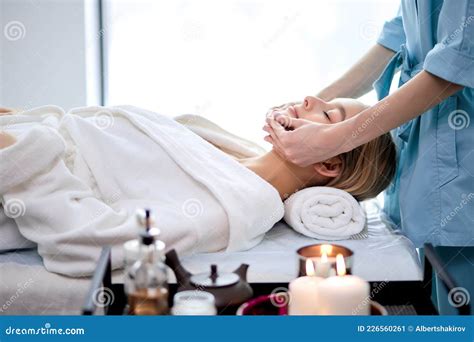 Female Lying With Closed Eyes And Having Face Or Head Massage In Spa By Professional Stock Image