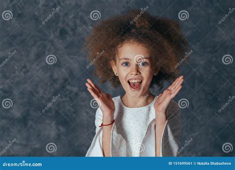 Smiling Pretty Girl With Curly Hair Holds Hands Near Face And Is Delighted Stock Image Image