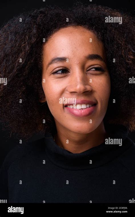 Young Beautiful African Woman With Afro Hair Against Black Background