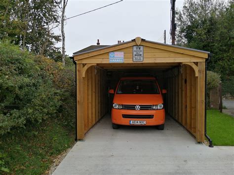 The timber also mimics the rustic chateau design of the home. Wooden Carports in Devon by Shields Garden Buildings