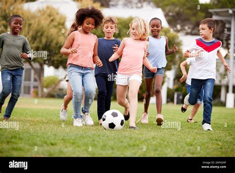 Grupo De Niños Jugando Al Fútbol Con Sus Amigos En El Parque Fotografía