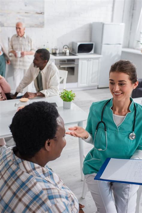 Nurse With Clipboard Talking To African Stock Photo Image Of Nurse