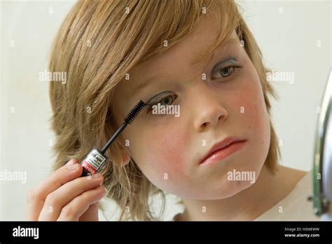 Young Boy Putting Makeup On Pretending To Be A Girl Stock Photo Alamy