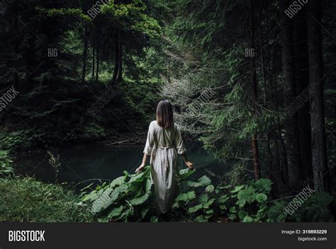 Beautiful Young Woman Wearing Elegant White Dress Walking On A Forest