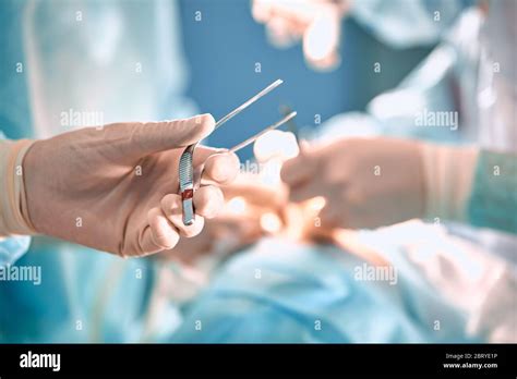 Doctor's hand holding tweezers in the operating room. Surgical