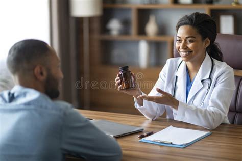 Cheerful Black Lady Doctor Prescribing Medication To Male Patient Stock