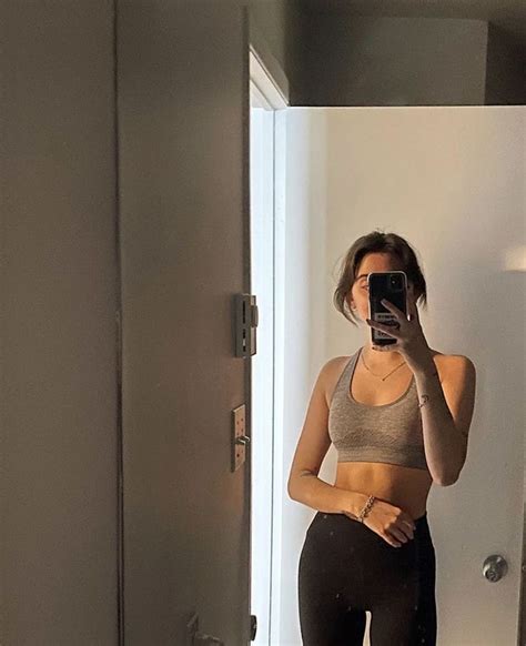 A Woman Is Taking A Selfie In The Mirror While Wearing Leggings And Sports Bra