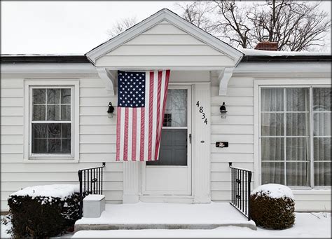 20+ ideas for american flag front door decor. American flag hanging over the front door of a little ...