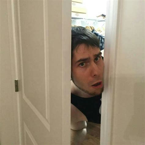 A Man Peeking Out From Behind A Door