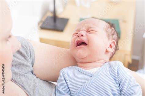Newborn Crying In His Mothers Arms Stock Photo And Royalty Free