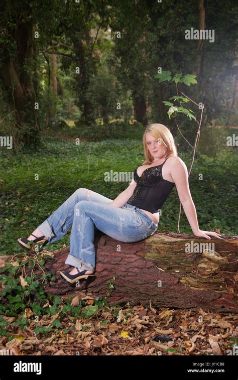 Pretty Blonde Girl In A Forest Location Wearing Jeans And A Black Top