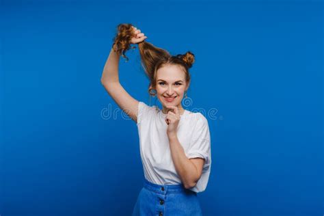 A Young Stylish Girl Pulls Her Hair On A Blue Background A Model Pulls Her Long Hair Stock