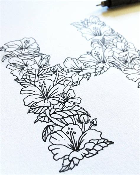 A Drawing Of Flowers On Paper Next To A Pen