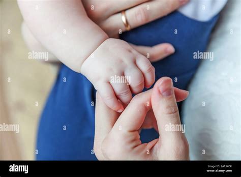 Tiny Newborn Infant Male Or Female Baby Hand Holding Mother Finger