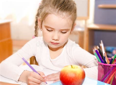 Cute Little Girl Is Writing At The Desk Stock Image Image Of People