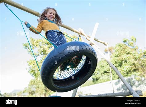 Girl Playing On Tire Swing Stock Photo Alamy