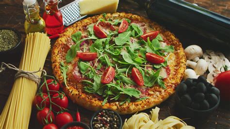 Italian food background with pizza, raw pasta, spices, herbs, wine, and ...