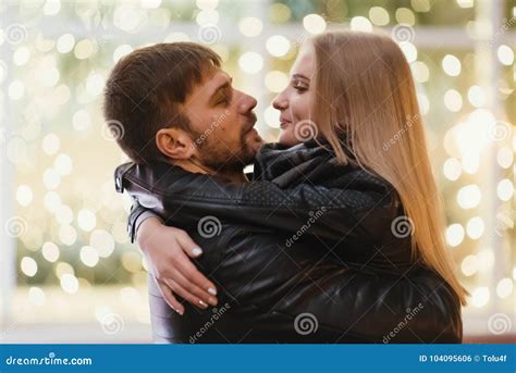 An Attractive Couple In Love Embrace And Enjoy An Intimate Moment Together Against The Backdrop