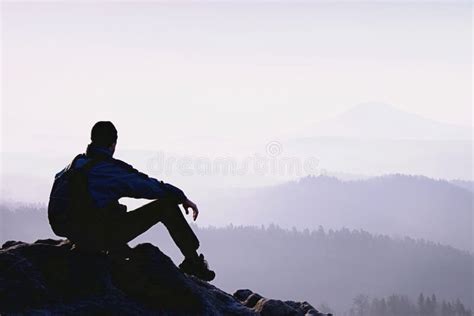 Thinking Man Sit On Rock Man On Exposed Summit Watching Stock Image