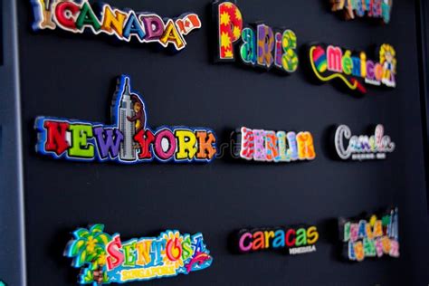 Souvenirs Magnets From All Over The World Placed On A Black Fridge