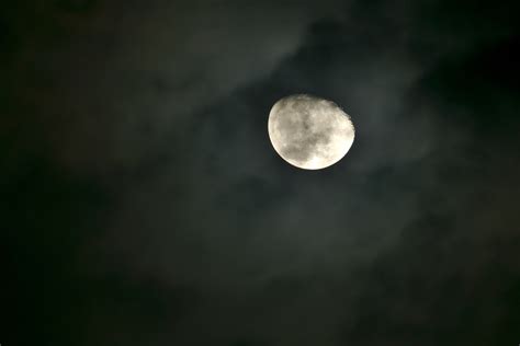 A Bright Moon In The Night Sky Surrounded By Wispy Clouds Lunar In