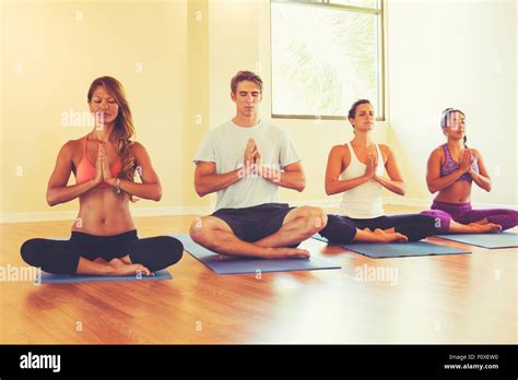 group of people relaxing and meditating in yoga class wellness and healthy lifestyle stock
