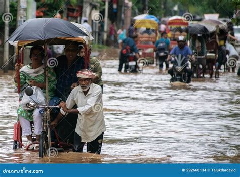 commuters on a rickshaw to cross a waterlogged road after heavy rainfall on october 6 2023 in