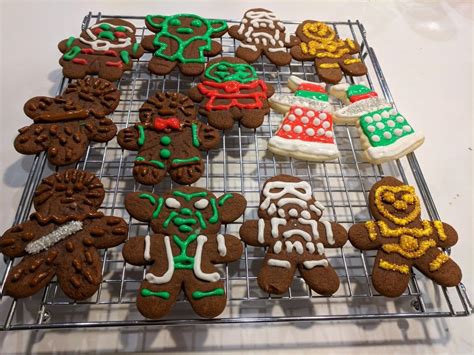 some cookies are on a cooling rack and one is decorated with icing, the