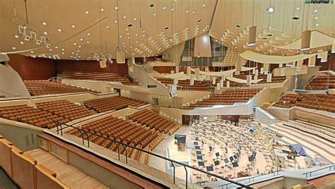 A Large Auditorium Filled With Lots Of Brown Seats And Chandelier